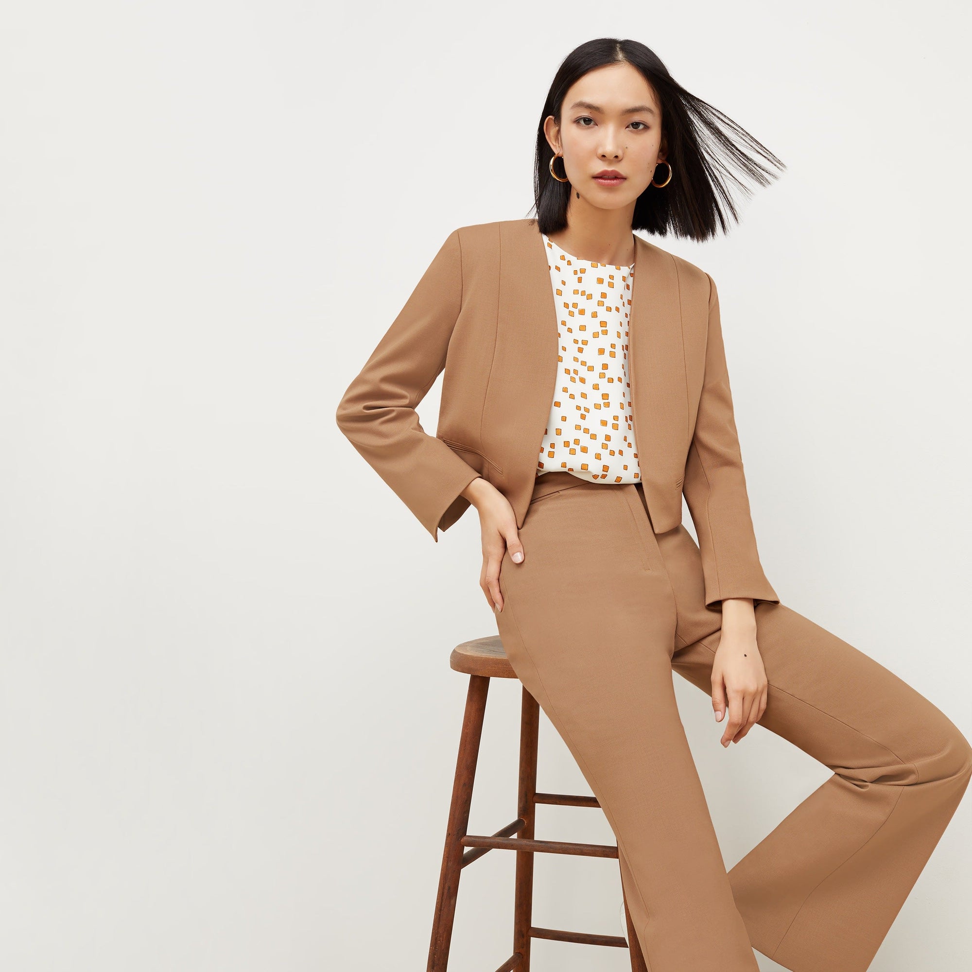 Front image of a woman standing wearing the Neale jacket in camel | Exclude