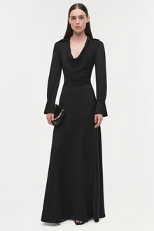 Black satin gown with cowl neckline, long draped sleeves, and A-line skirt, styled with black clutch.