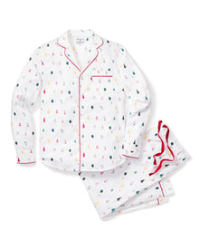 The Mens Twill Pajama Set in Merry Trees by Petite Plume includes a white button-up shirt and pants made from top-quality cotton, featuring small red, green, and black tree patterns. The shirt has a chest pocket and red piping, while the pants offer an elastic waistband for comfort—perfect for Christmas.