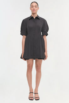 Black button-front shirt dress with puffed sleeves and fitted waist, shown on model wearing black sandals.