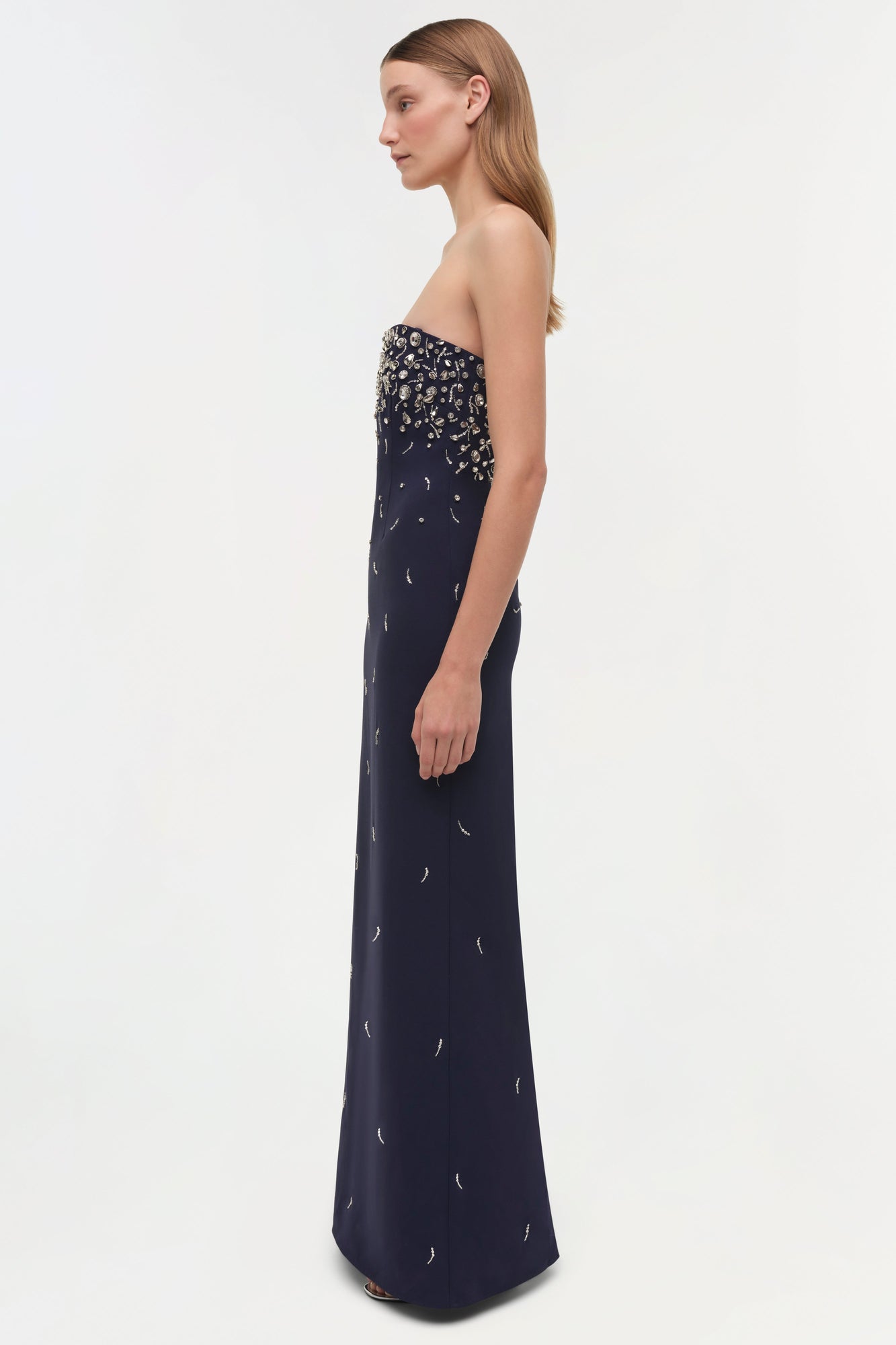 Navy strapless gown with silver beaded embellishments concentrated at bodice, scattered down skirt.