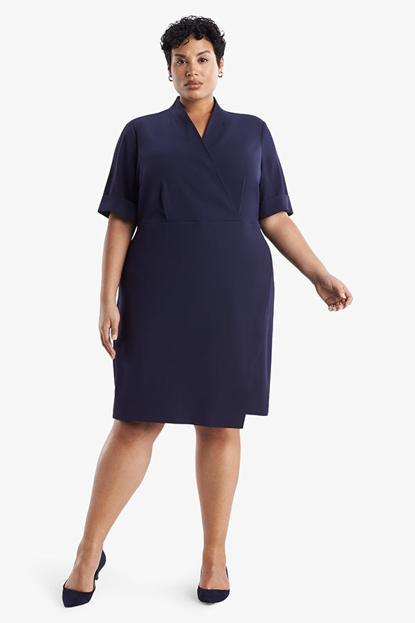 Front image of a woman standing wearing theTory Dress in dark iris | Plus | Exclude