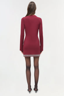 Burgundy knit mini dress with long sleeves and beaded embellishment at hem, shown from back.