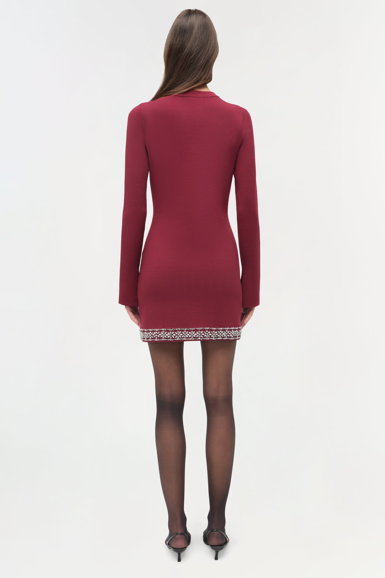 Burgundy knit mini dress with long sleeves and beaded embellishment at hem, shown from back.