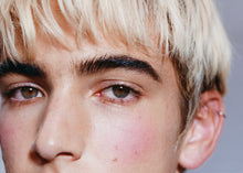 A close-up of a model's face, staring directly into the camera.