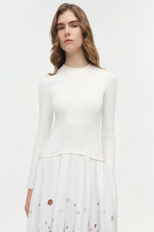 White ribbed knit midi dress with embroidered circular cutouts on the skirt hem.