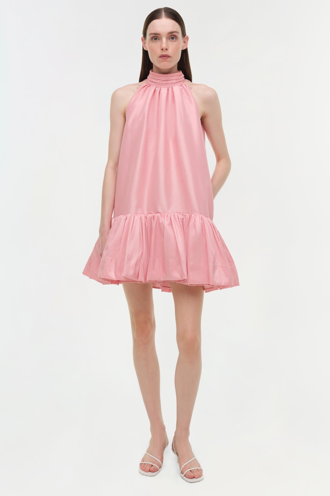 Pink taffeta halter mini dress with ruched high neckline and ruffled drop hem.