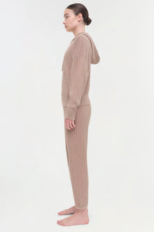 Beige cable knit hoodie and matching pants on model shown from the side.