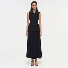 Black sleeveless vest dress with buttoned front and pleated ankle-length skirt.