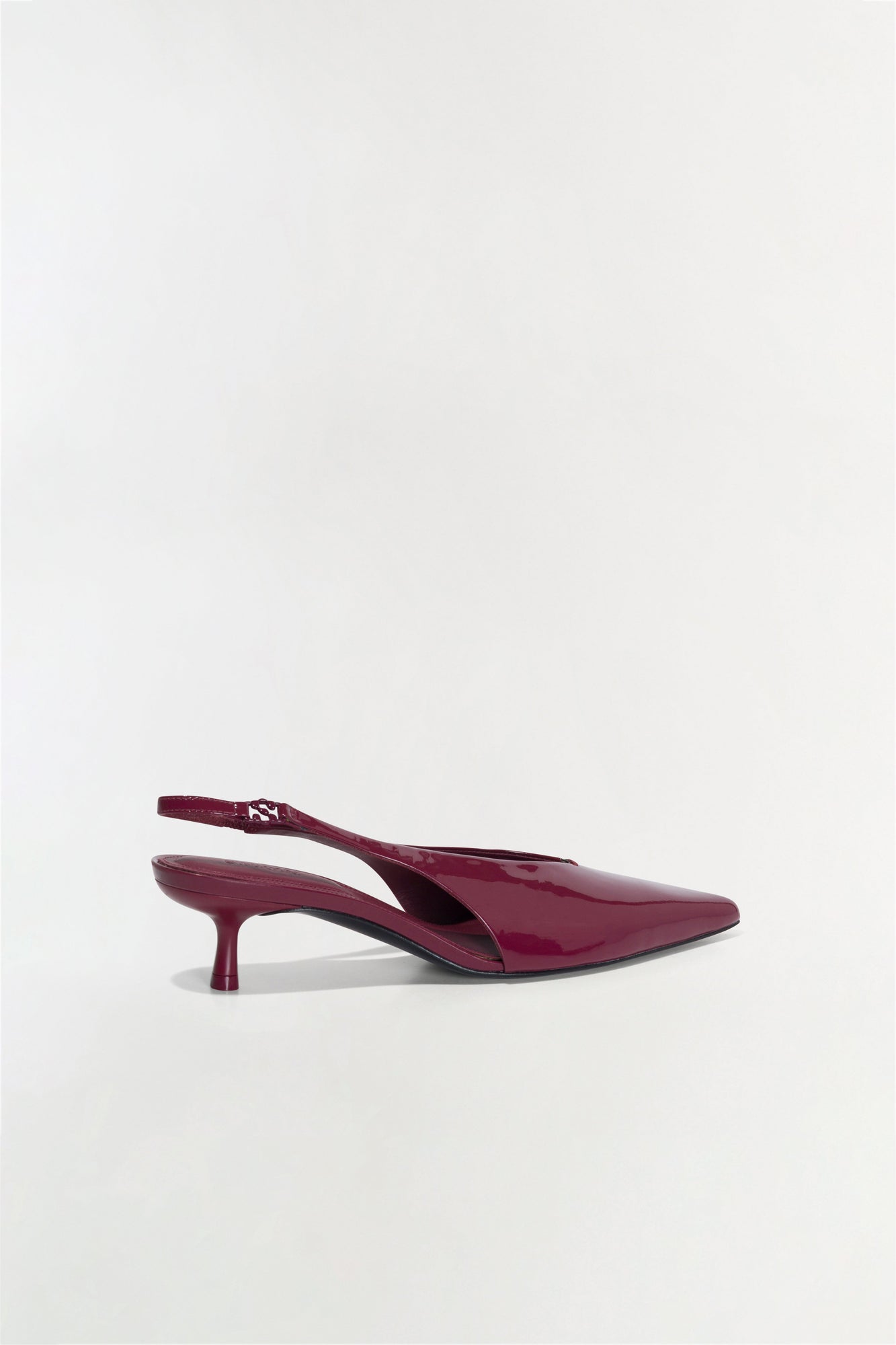 Burgundy patent leather slingback heel with pointed toe and thin kitten heel, shown in side profile.
