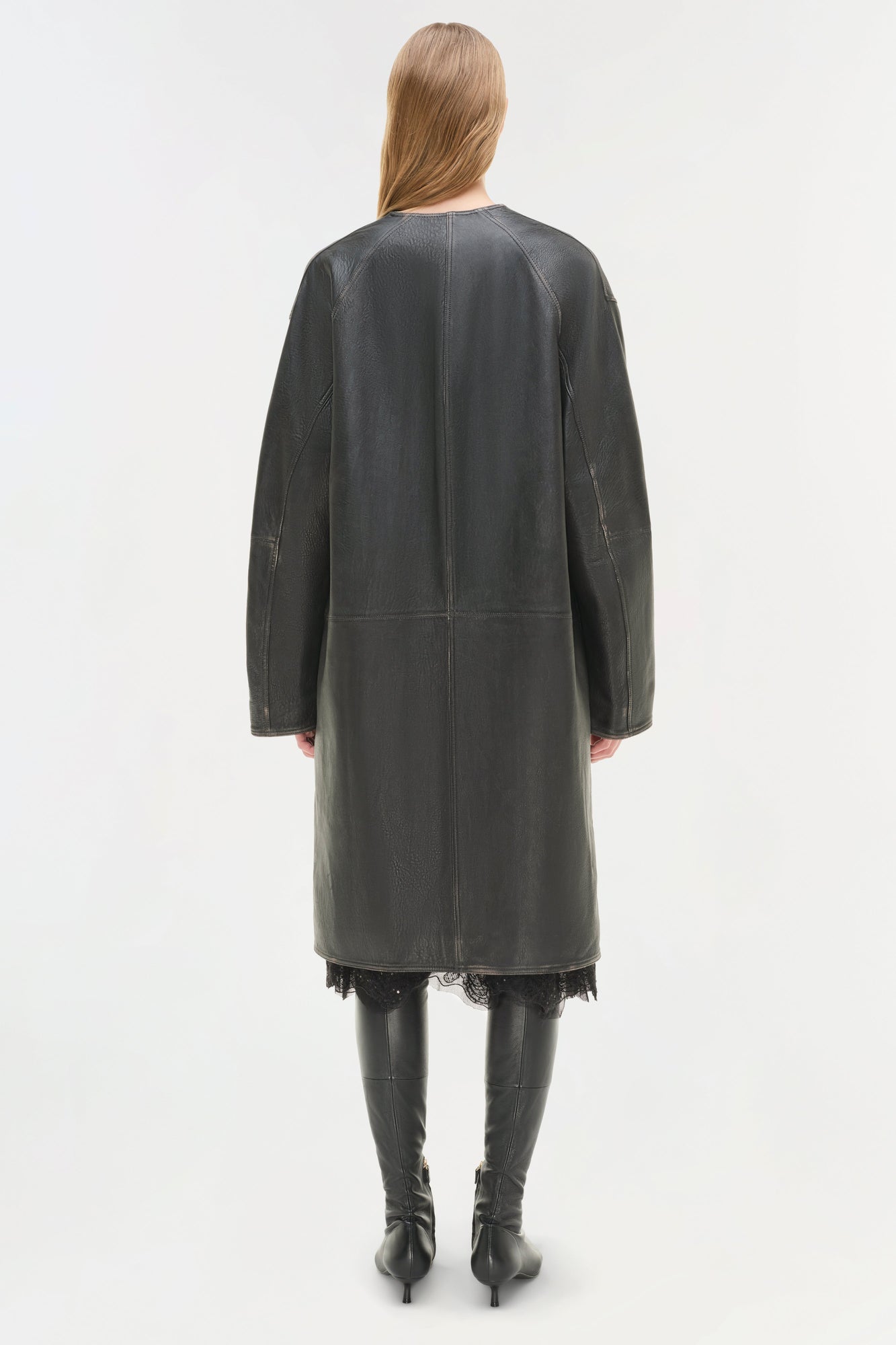 Dark gray leather coat worn over black lace dress, shown from back with matching knee-high black leather boots.