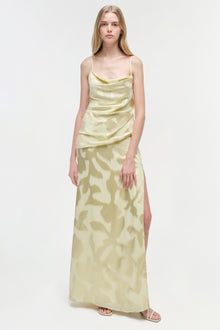 Cream-colored satin gown with abstract leaf print, cowl neckline, thin straps, ruched bodice, and side slit.