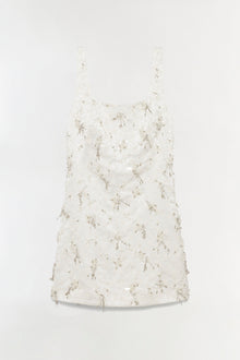White mini dress with square neckline and beaded tassel embellishments throughout.