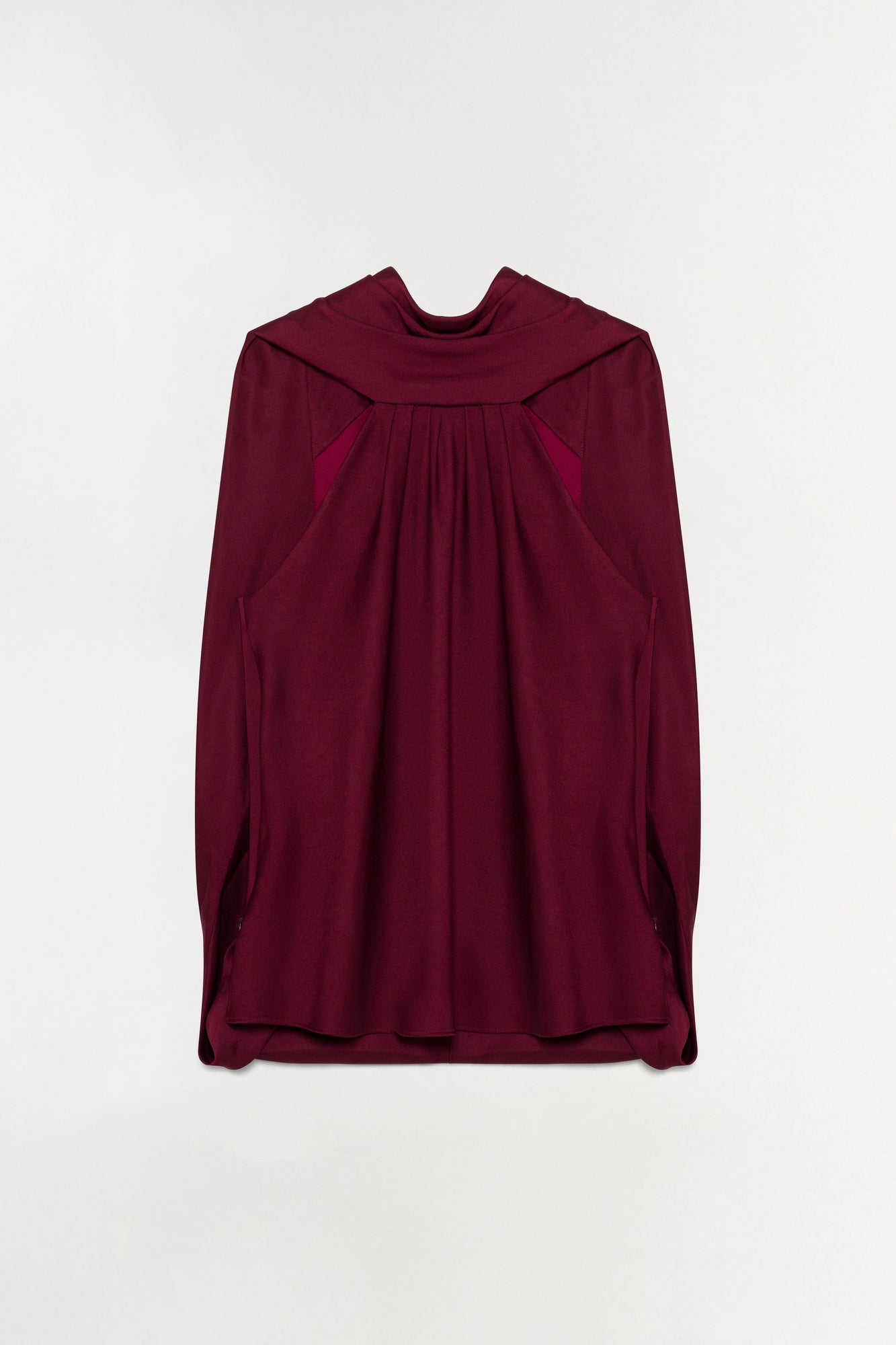 Deep burgundy satin cape top with draped front panel and long sleeves on neutral background.