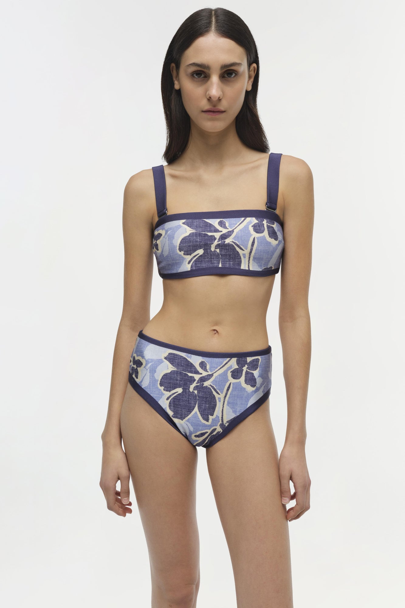 Blue and white floral patterned bikini top with navy straps and trim on model.