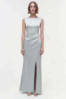 Light gray sleeveless floor-length gown with ruched waist detail and side slit, worn with flat sandals.