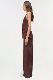 Woman wearing burgundy pinstriped sleeveless top with square neckline and matching wide-leg pants.