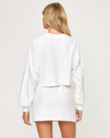 Back view of model wearing the Half Court Skirt in white with matching white Half Court Pullover.