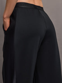 Model wears black wide leg pants with an elastic waistband. 