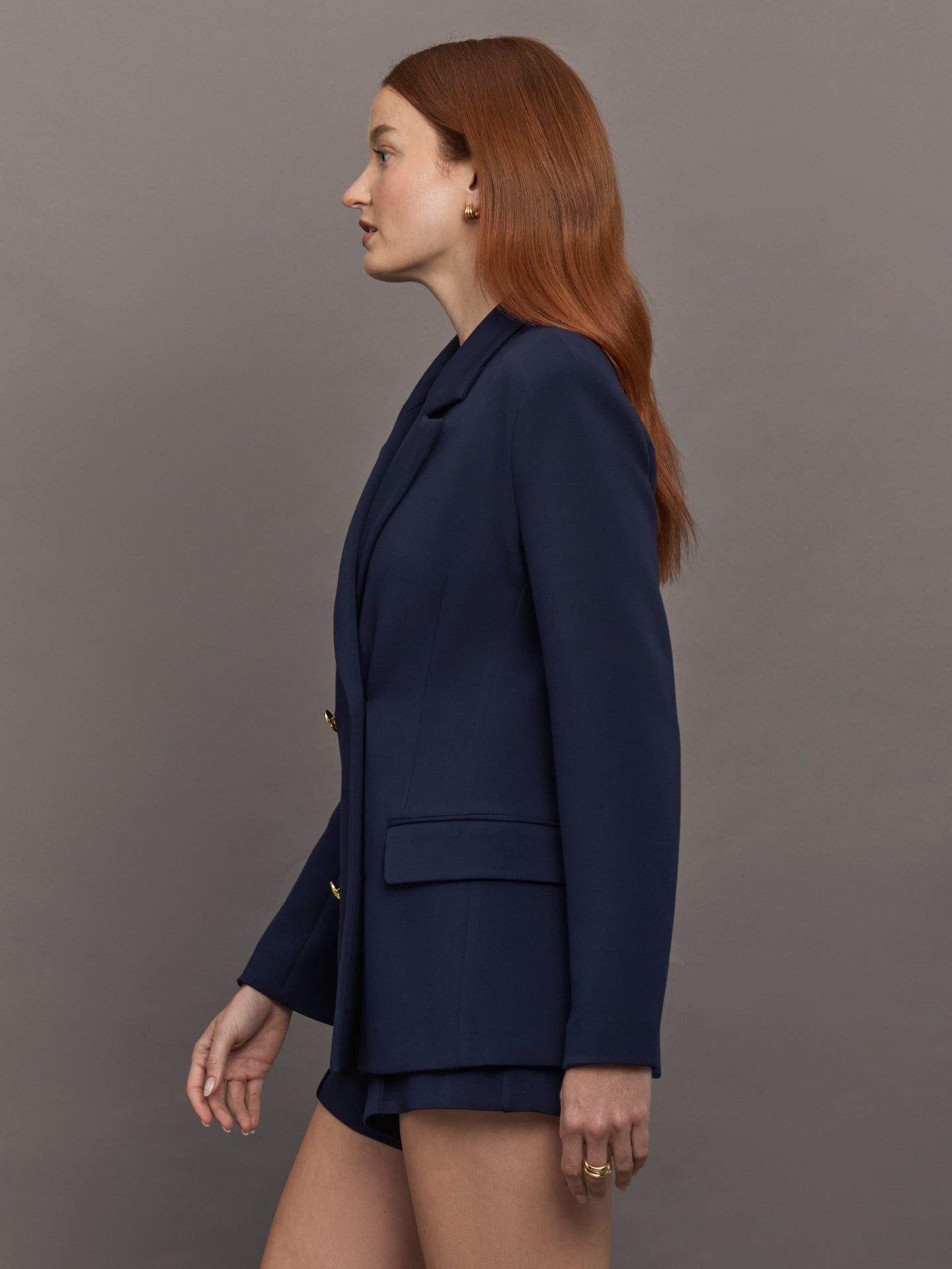 Model wears the Navy double-breasted blazer in Scuba, with a tailored fit, and a smooth, contoured finish.