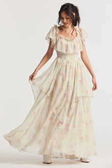 Cream maxi dress with elastic off-the-shoulder silhouette, ruffles around the neck, and a shaped skirt with ethereal tiers.