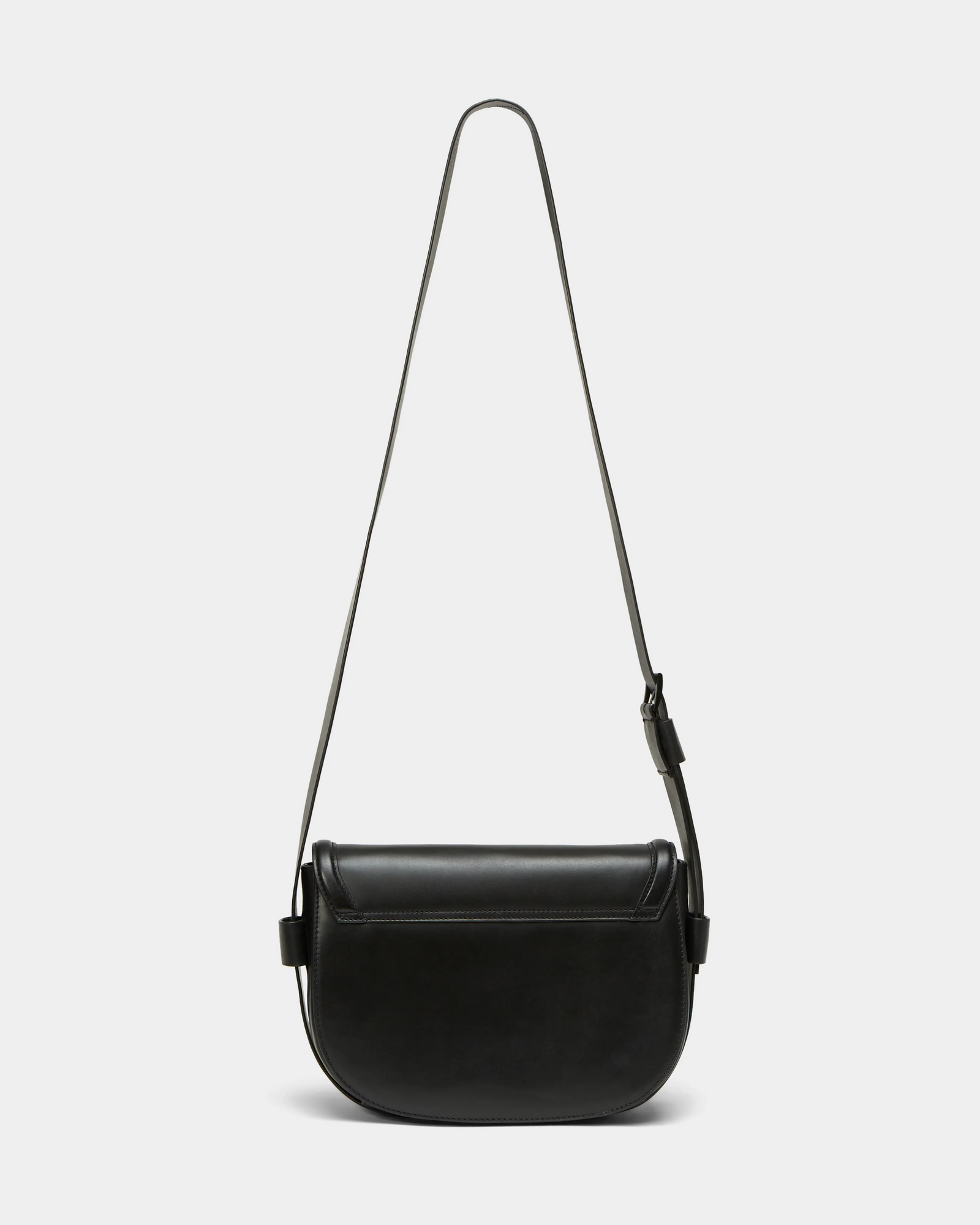 The ALORA - 8324506 Black by Rudsak is a women’s leather crossbody bag with a long adjustable strap and curved rectangular shape, shown against a plain white background.