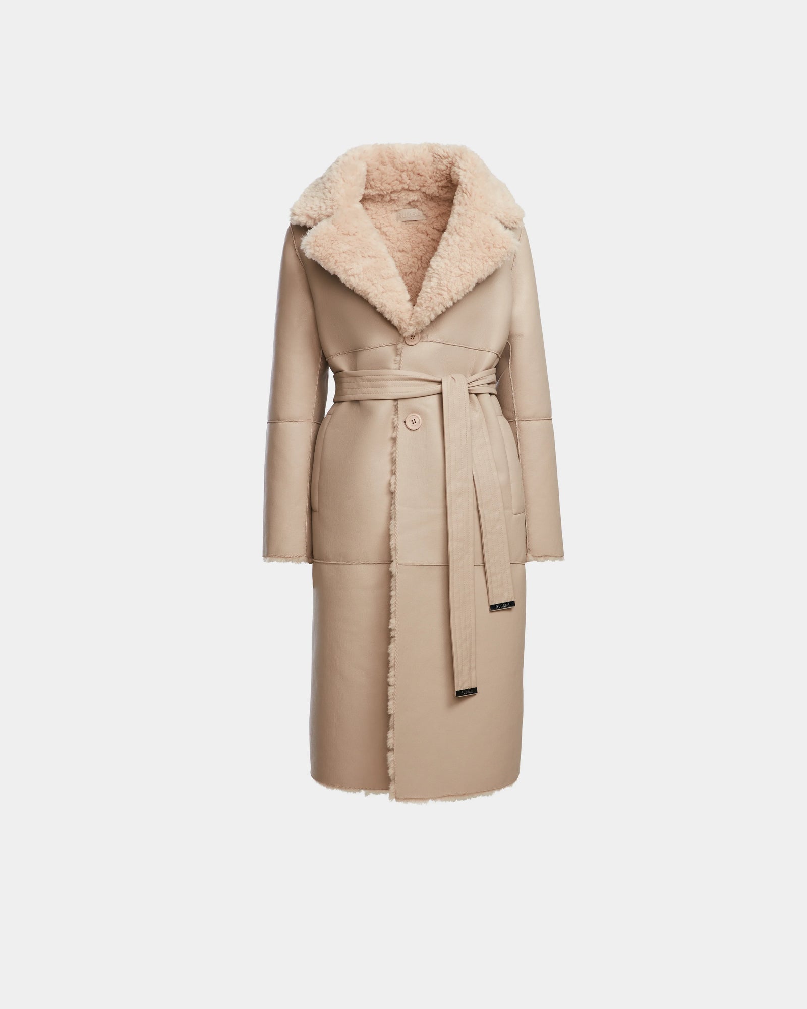 The ANNABELLE - L124544 Sand by Rudsak is a women’s beige reversible teddy coat with a wide, fluffy collar and lapels, matching tie belt, visible seam details, soft textured lining, and a straight silhouette.