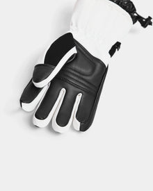 A close-up of the Rudsak APLEN - 6424505 Optic White insulated ski glove featuring reinforced knuckles, a black palm, waterproof zippers, and an adjustable wrist strap, displayed on a white background.