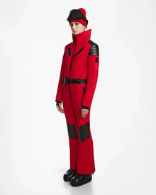A woman stands out in the bold Flame Red ARLEY - 8124717 one-piece ski suit by Rudsak.