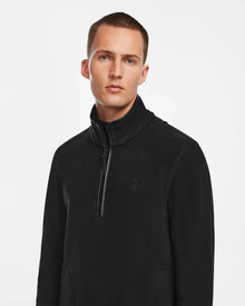 A young man with short hair models the Rudsak BECK - 6524538 Black men’s fleece half-zip pullover with vegan leather trims, standing against a plain white background and looking directly at the camera—ideal for casual wear.