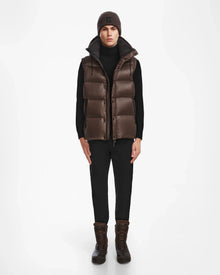 A person faces forward wearing the Rudsak BOBBY - 6124506 Espresso mens down puffer vest over a black turtleneck, black pants, brown boots, and a brown knit beanie against a plain white background.