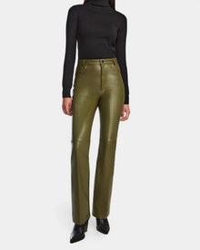 A person stands against a plain white background wearing Rudsak’s CARISSA - 8524545 Loden Green high-waisted pants with a fitted black turtleneck and black pointed-toe shoes; their face is not visible.