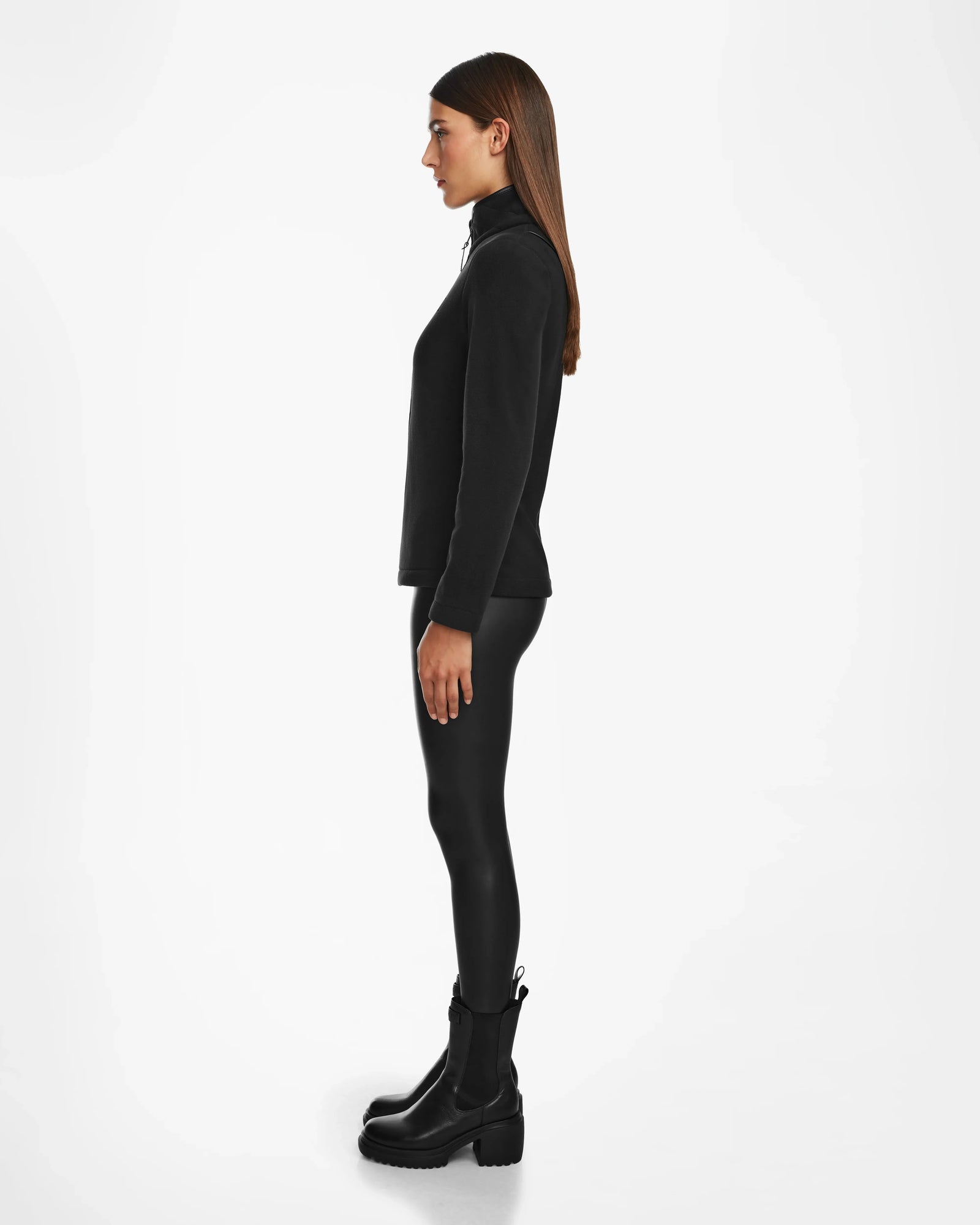 A woman in black clothing sports the Rudsak EDITH - 8524617 zip-up sweater, giving her outfit a modern edge.