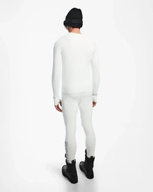 A person faces away, wearing the Rudsak FRANC - 6524541 Iceland white stretch base layer top and leggings, black winter boots, a black beanie, and black goggles against a plain white background.
