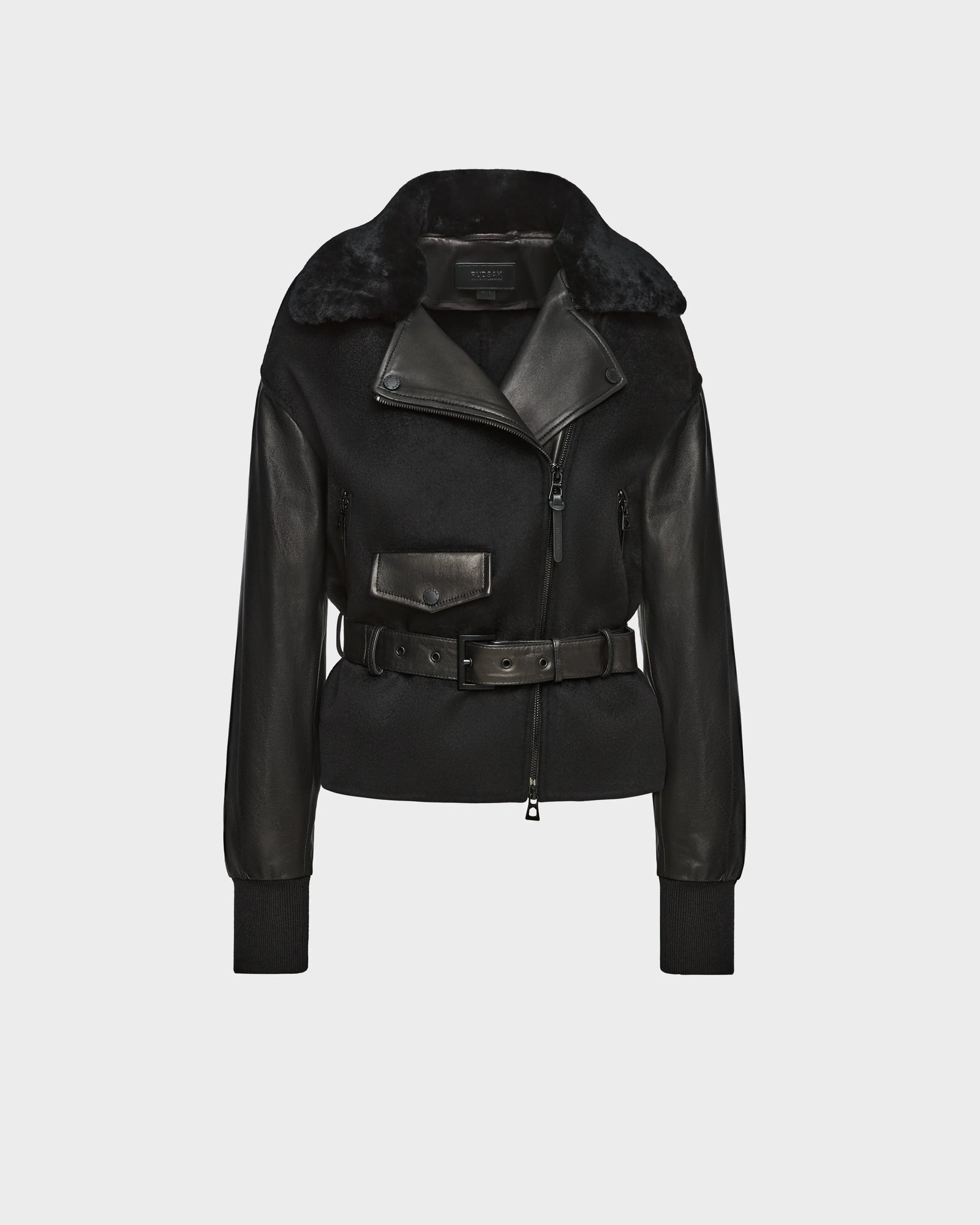 The Rudsak HALA - 8124521 Black womens jacket features black leather and shearling, an asymmetrical zipper, wide lapel, front pocket, and belted waist—shown on a plain light gray background for a chic fall look.