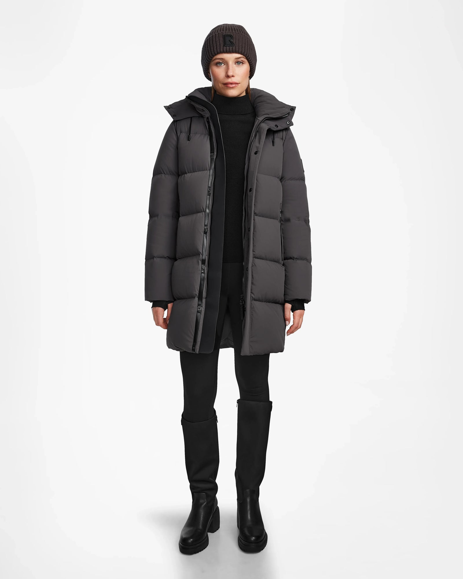 A woman in the Rudsak JOELLE - 8124729 Grey long quilted down coat and a black hat, styled perfectly for winter.