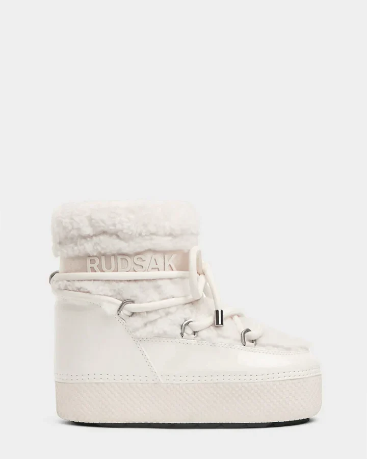 The KATHY - 8223513 Iceland by Rudsak is a white women's winter boot with a thick sole, faux shearling trim, lace-up front, and Rudsak branding on the ankle strap, shown against a plain light background.