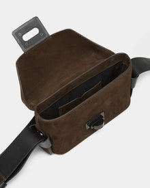 The Rudsak OFILIA S - 8324521 Espresso crossbody bag features suede, a black leather strap, an empty interior with a small inner pocket, and a flap secured by a magnetic clasp.