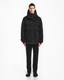 A man wearing the Rudsak ROKO - 6124510 Black mens quilted down parka.