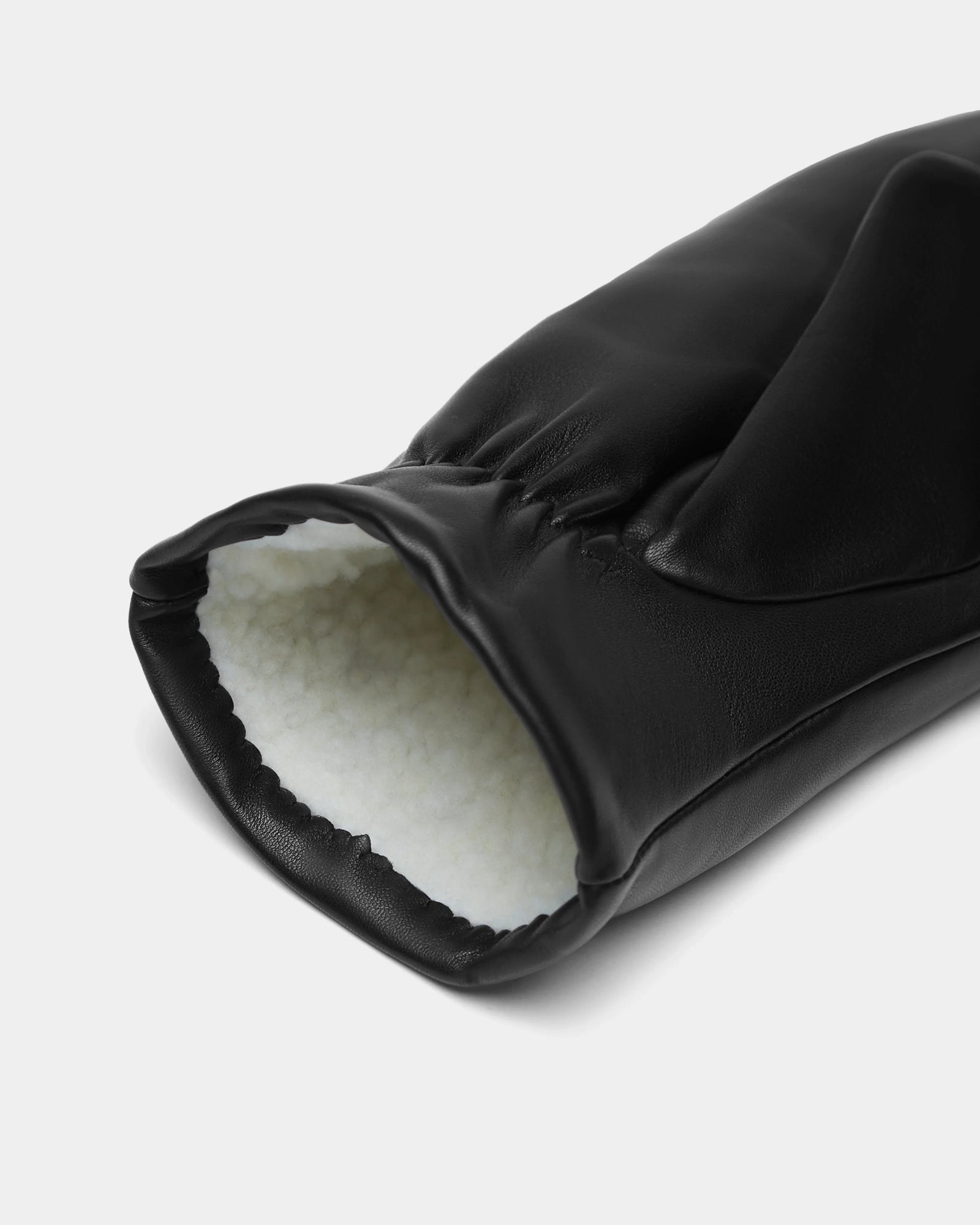 A close-up of Rudsak’s SELMA - 8424508 Black women’s leather mittens, showcasing the white, soft faux shearling lining inside the cuff—a must-have winter essential.
