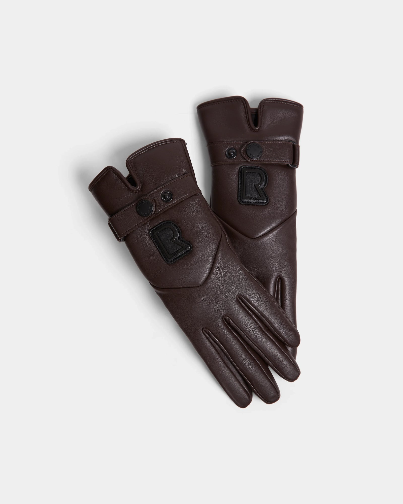 The Rudsak STROMBOLI - 8424510 Espresso women’s winter gloves feature dark brown leather, snap closures, black patch details, and a raised R on each glove, shown on a white background.