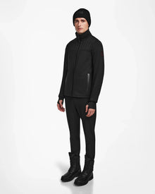 A man wearing black clothes, including the Rudsak TREVOR - 6124519 mens ski jacket designed for technical performance and equipped with RECCO rescue technology.
