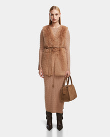 A woman poses against a white backdrop in the Rudsak YOLANDA - 8124790 Camel: a long, tan cable-knit dress styled with brown boots and a tan suede handbag—an ideal addition to your fall and winter wardrobe.