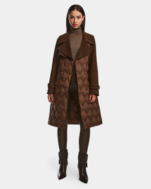 A woman faces forward against a white background, wearing the Rudsak ZOE - 8124711 Mocha quilted down wool trench over a taupe turtleneck, black leggings, and brown heeled ankle boots.