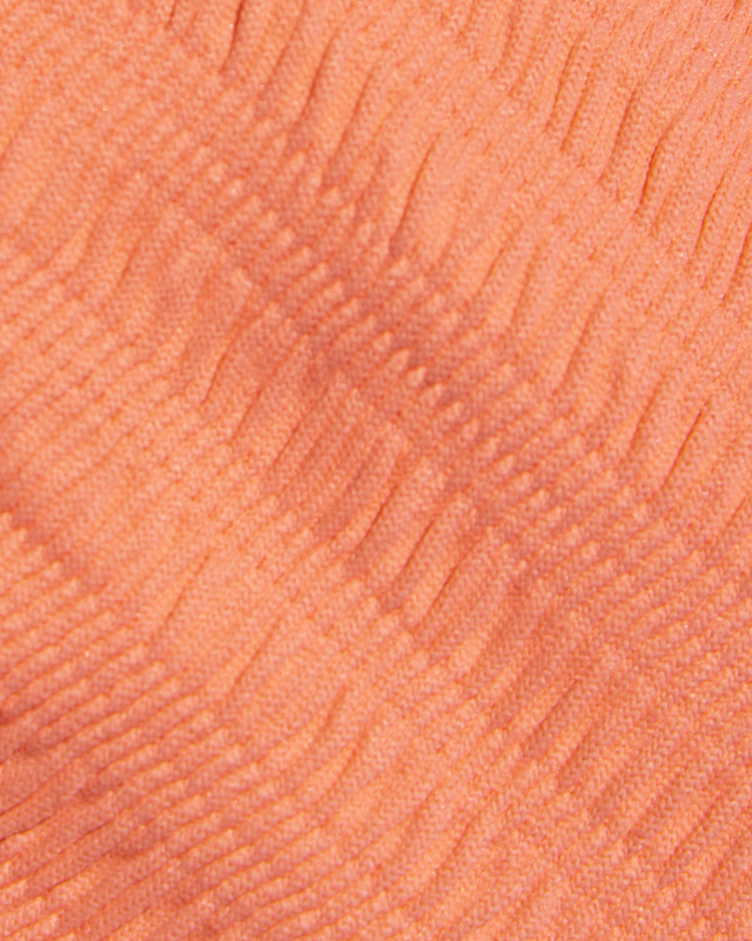Close-up of a textured orange-colored fabric surface