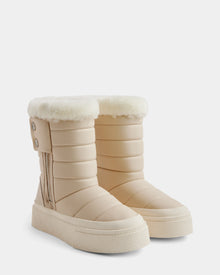 The Rudsak KATHIE - L225516 Vanilla women's mid boots, beige and quilted with thick white faux fur lining, side zippers, and outer decorative buttons, are displayed on a white background.