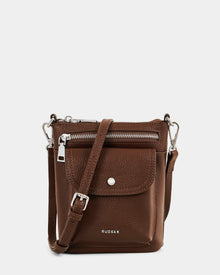The LILA - L325513 Mocha by Rudsak is a compact brown pebbled leather crossbody bag with a front zip pocket, flap pocket with snap button, and adjustable strap. 