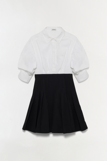 White cotton shirt dress with black pleated skirt and collar detail.