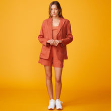 Front view of model wearing the linen oversized blazer in faded rust.