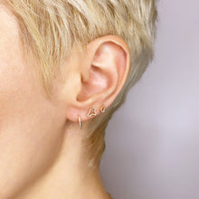 14k recycled gold Full Pave Ripple Stud Earring styled on a ear, layered with multiple studs